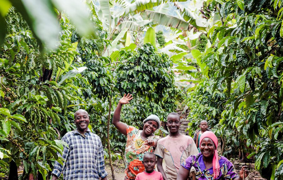 Familie Muhaiwwe, kinderen en oma op tussen de bananenbomen en koffieplanten